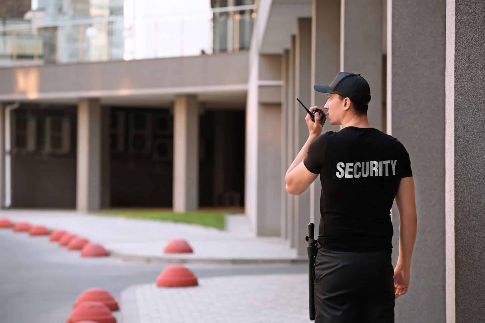 Male security guard with portable radio, outdoors